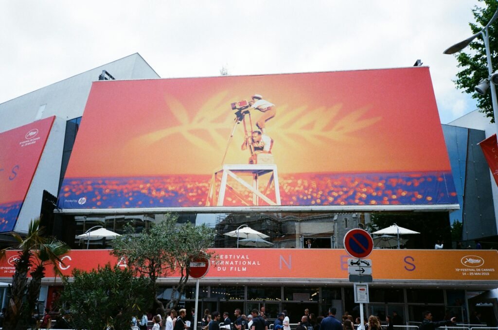 pexels-photo-2422404-2422404 Large billboard at the Cannes Film Festival showcasing vibrant imagery.